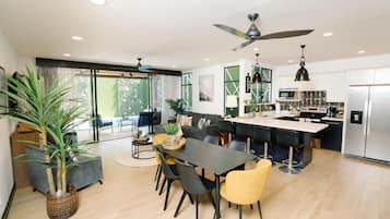 Una cocina moderna con zona de comedor, ventanas amplias y un ventilador de techo.
