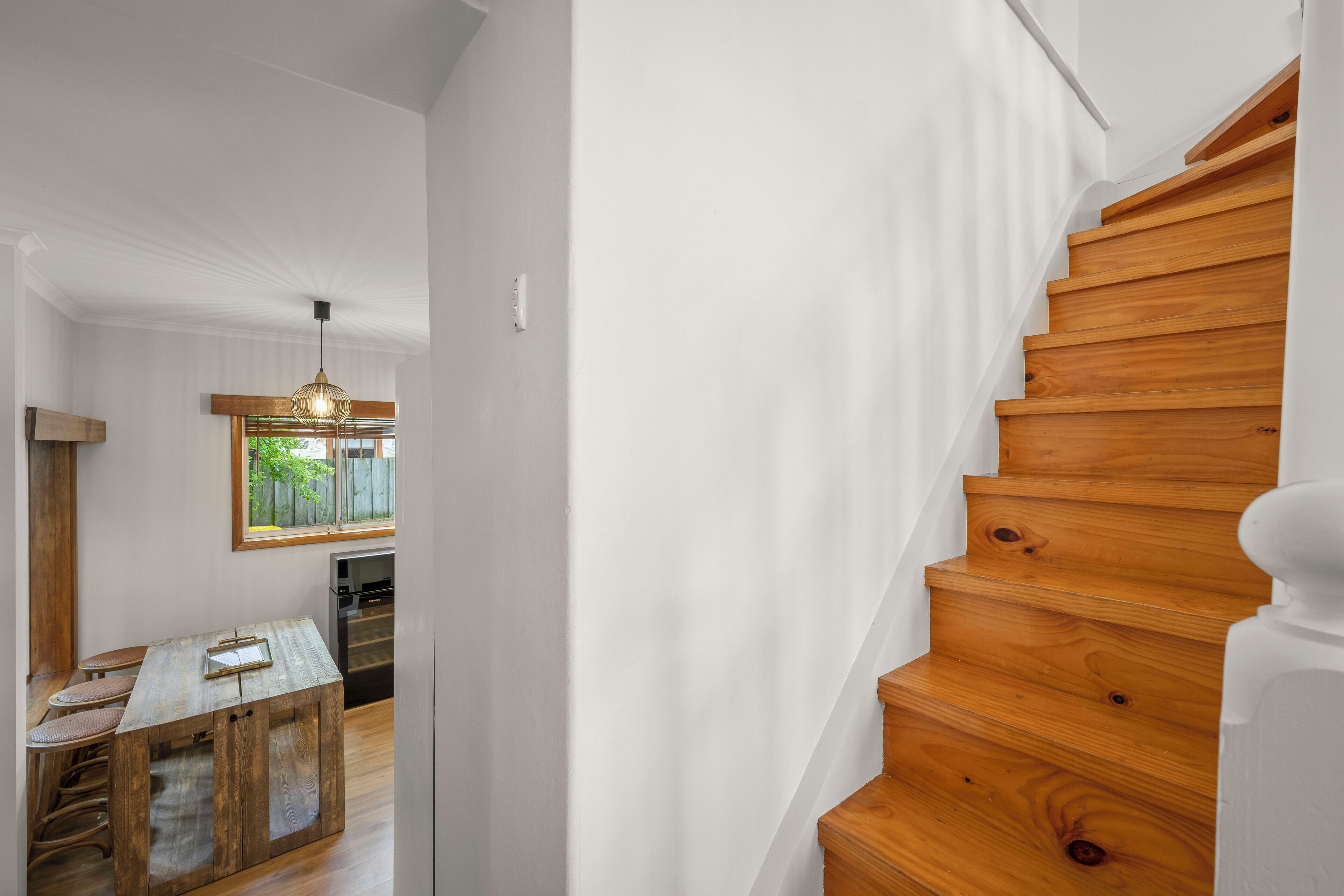 A staircase with wooden steps and white walls.