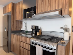 Enjoy cooking in this well-equipped kitchen with a stove, microwave, and coffee maker.