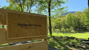 Un letrero de madera con la inscripción 'Highpoint House' y una dirección.