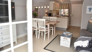 A modern apartment with a dining area, kitchen, and living space.