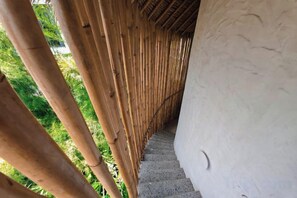 A bamboo structure with a staircase leading to a white wall. - Hillstone Luxury Village (Bali)