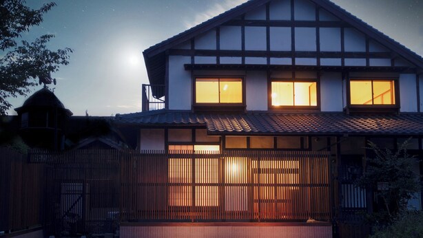 Ein traditionelles japanisches Haus mit einem Ziegeldach, Holzwänden und einem Holzzaun.