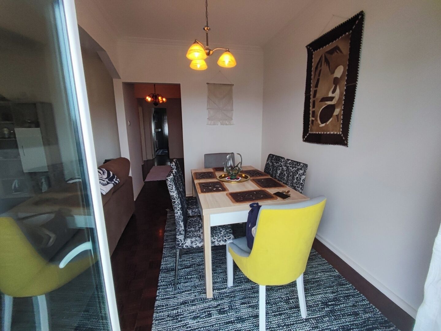 Un espace repas comprenant une table, des chaises et un lustre.