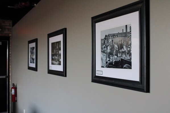 A hallway with three framed black and white photographs on the wall. - 4th Street Lofts (Bemidji)