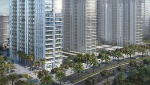 Een hoog appartementencomplex met meerdere balkons, omringd door palmbomen en een heldere lucht.