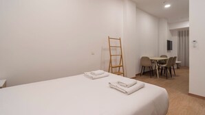 A hotel room with a bed, a desk, and a chair.