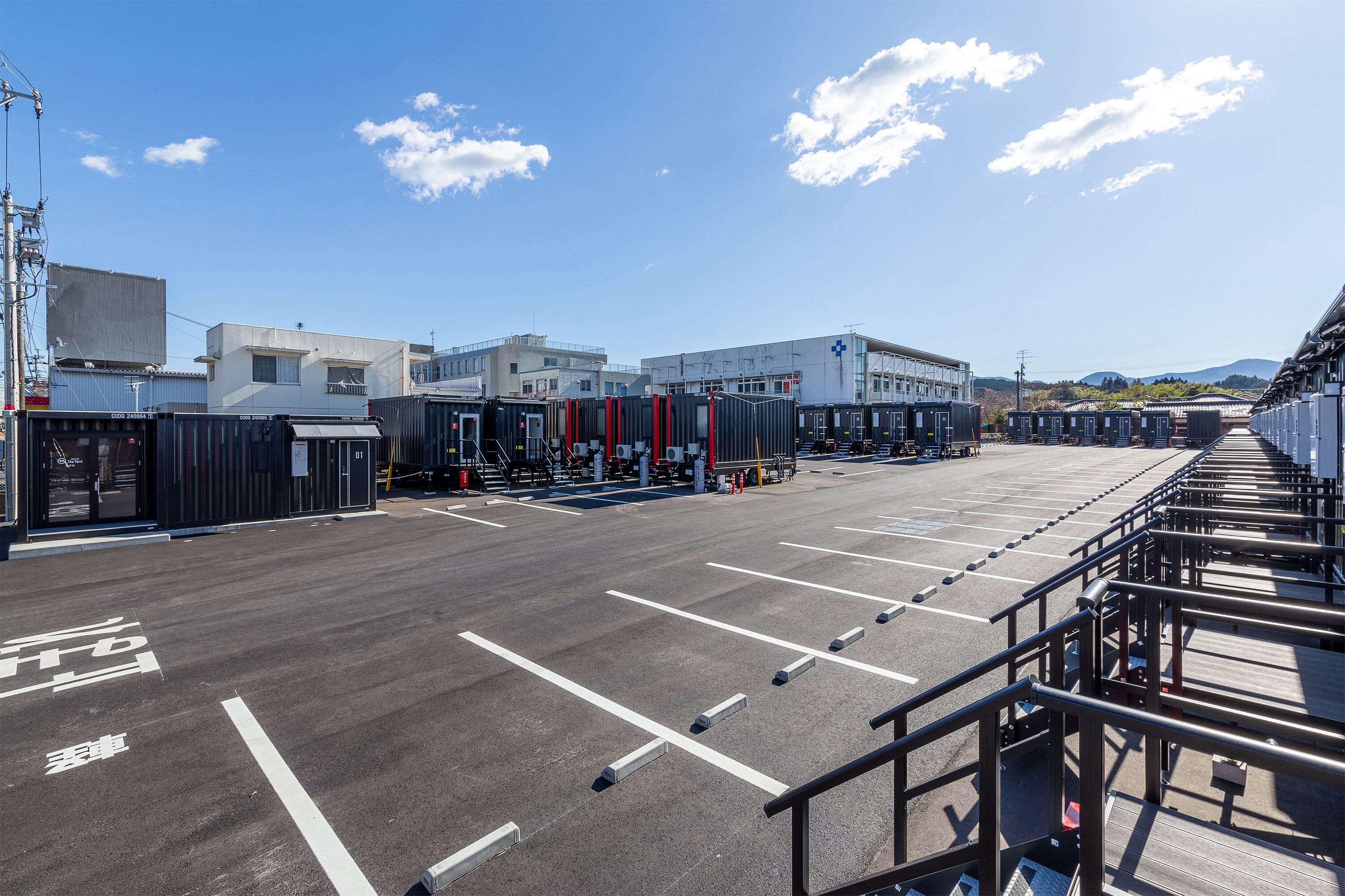 A parking lot with marked spaces and a building in the background.