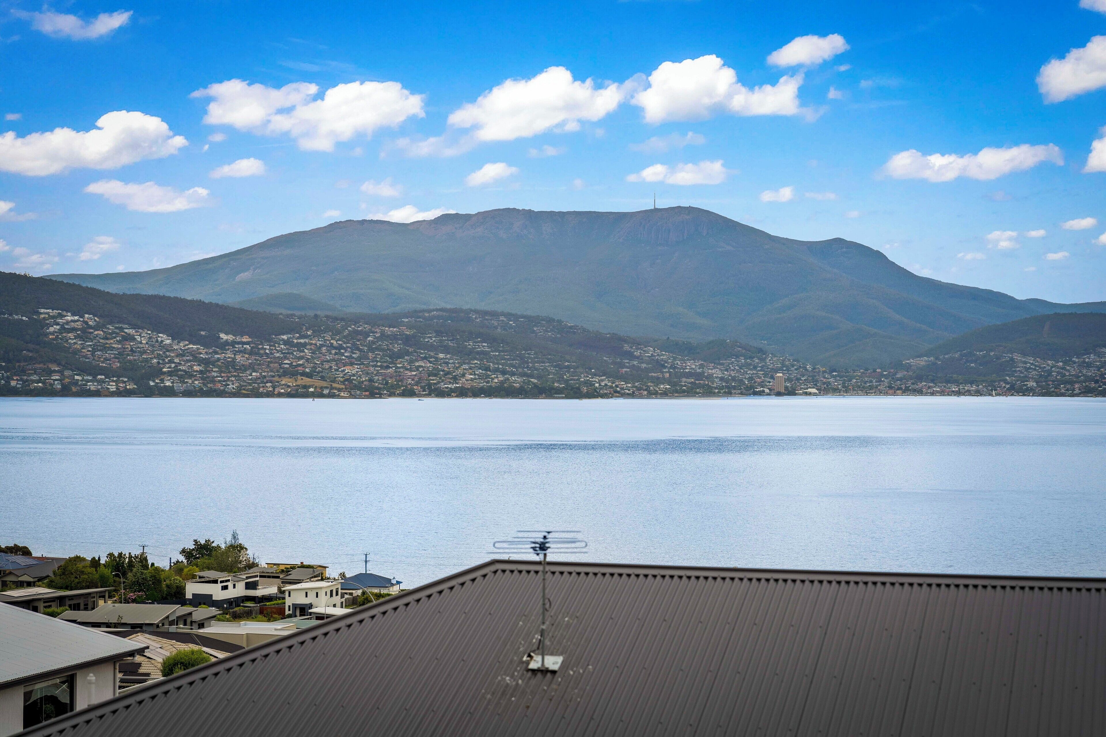 A residential area with a view of a mountain and a body of water.
