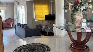 A spacious living area with a modern sofa, a glass coffee table, and a decorative vase. - Beautiful Tuscan Villa with pool amongst the vineyards and olive trees. (Kato Assos)