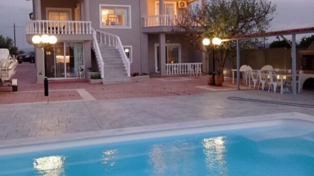A two-story house with a swimming pool, a covered patio, and a staircase leading to the upper floor. - Beautiful Tuscan Villa with pool amongst the vineyards and olive trees. (Kato Assos)