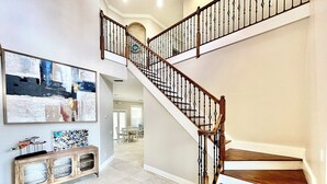 A staircase with wooden steps and black balusters, leading to an upper floor. - Azure Sky Spacious 5-bedroom house with WiFi and AC in enchanting Naples (Naples)