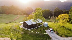 A rural property with a barn, a large cylindrical water tank, and a gravel driveway. - Jacaranda at Barranca - Luxury Villa (Kangaroo Valley)