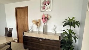 A reception desk with a wooden panel design, a vase with flowers, and a potted plant. - A three bedroom house with 2 bathrooms (Gresham)
