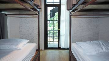 A room with two beds, a wooden ceiling, a door with a view, and a tiled floor.