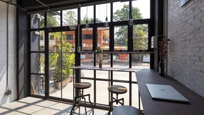 Et moderne interiør med store vinduer, to barstole, et bord og en bærbar computer.