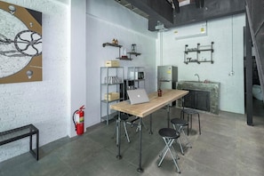 Una cocina moderna con una mesa de madera, taburetes de bar y un extintor.