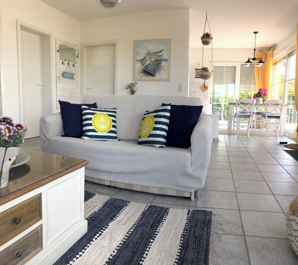 A living room with a grey sofa, striped cushions, a striped rug, and a painting on the wall.