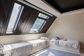 Une chambre avec deux lits, un bureau et une fenêtre donnant sur un beau paysage.