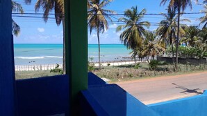 A view of a beach with palm trees and a clear blue sky. - Pousada da Kika  (Touros)