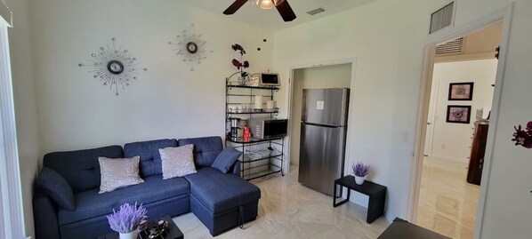 Relax in this stylish living room with a sofa, side tables, and a fully equipped kitchen.
