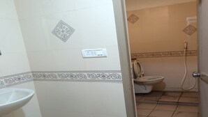 A bathroom with a sink, toilet, and shower area. - Elite Residency Pallavaram (Chennai)