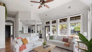 A spacious living room with two white sofas, a wooden coffee table, and a ceiling fan. - Resort-style, Frisco Getaway, Saltwater Pool, FREE Heated Spa (Frisco)