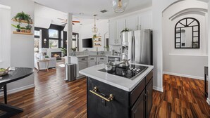 A modern kitchen with white cabinetry, a central island, and a stainless steel refrigerator. - Resort-style, Frisco Getaway, Saltwater Pool, FREE Heated Spa (Frisco)