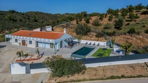 A two-story house with a swimming pool, surrounded by hills and sparse vegetation. - Quinta Ribeira do Arade (São Bartolomeu de Messines)