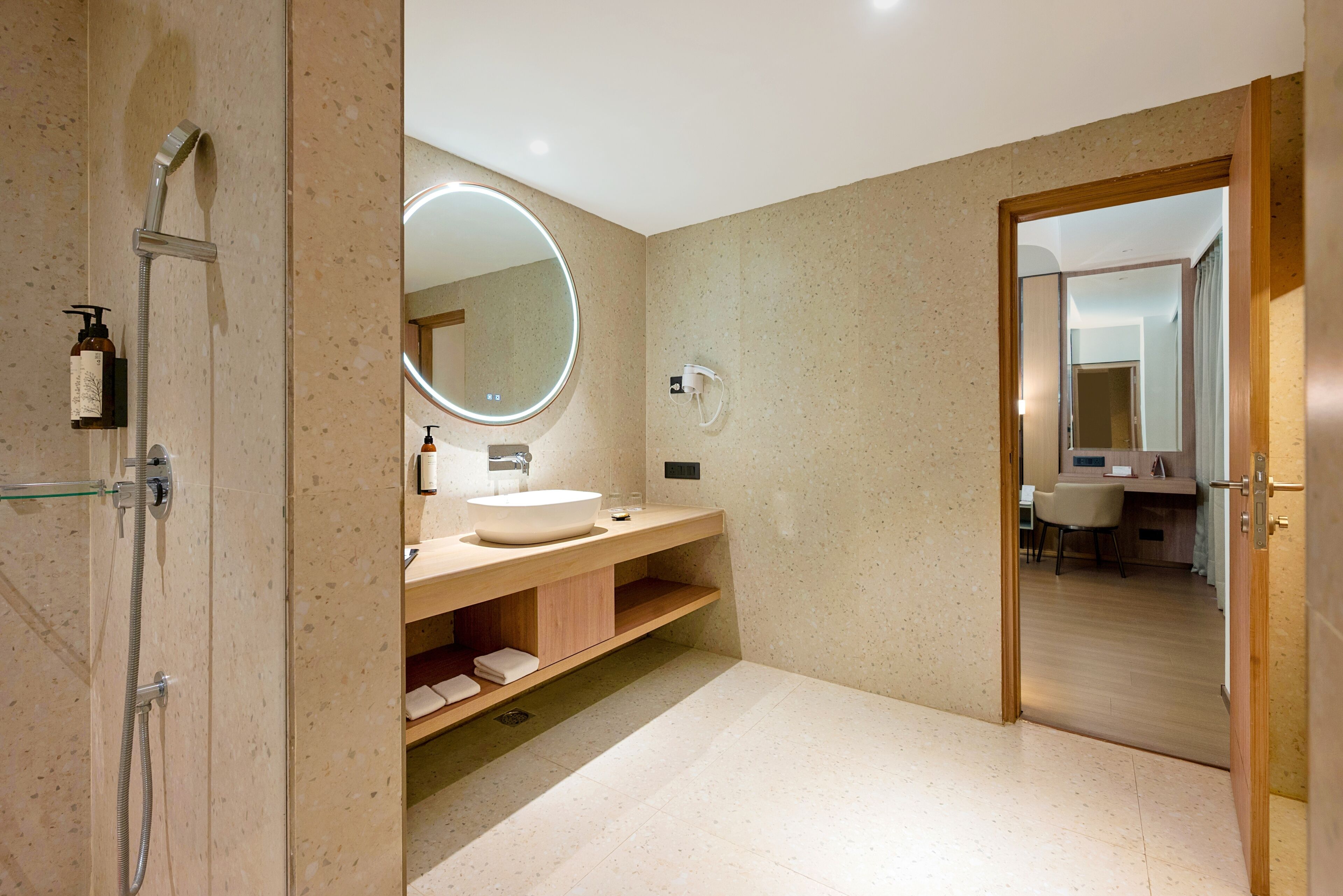 A modern bathroom with a walk-in shower, a large mirror, and a vanity with a sink.