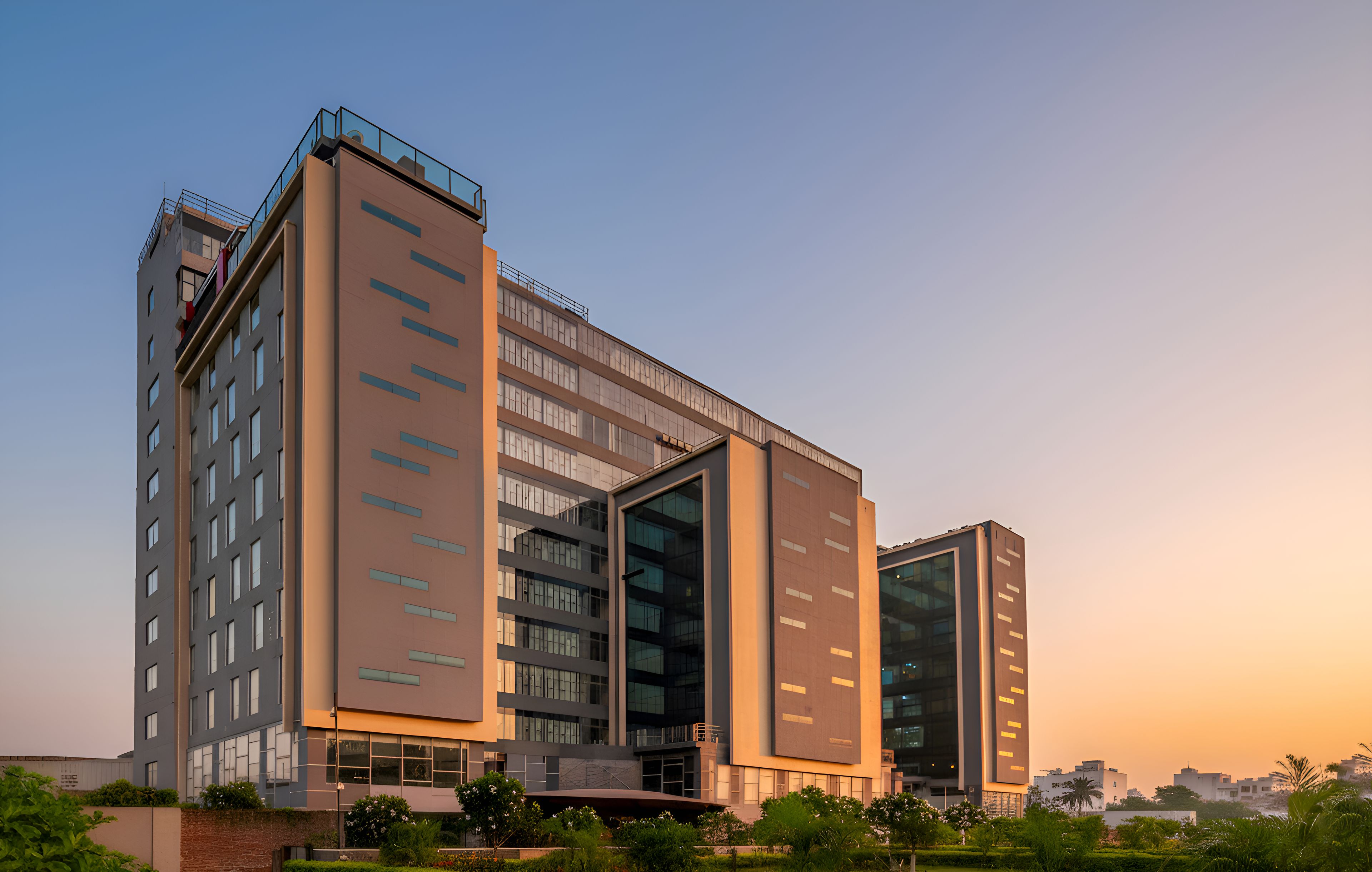 A modern multi-story building with a flat roof, large windows, and a prominent entrance.