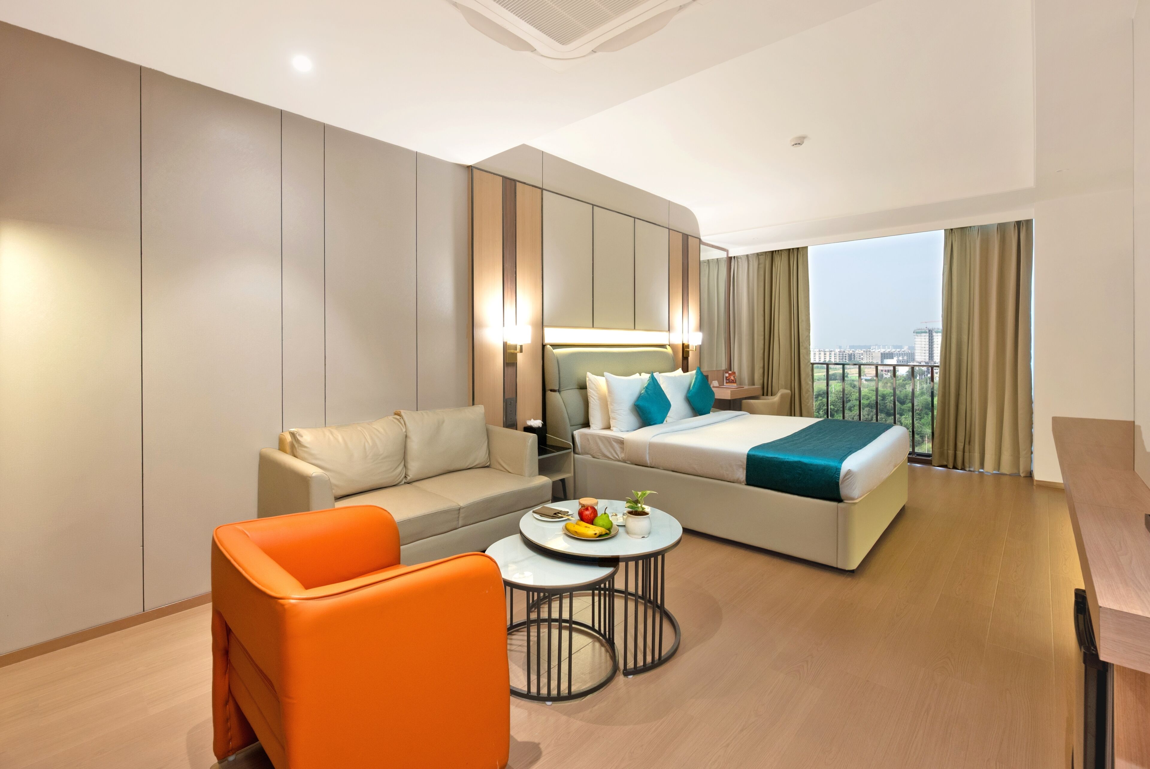 A hotel room with a bed, a sofa, a coffee table, and a chair.