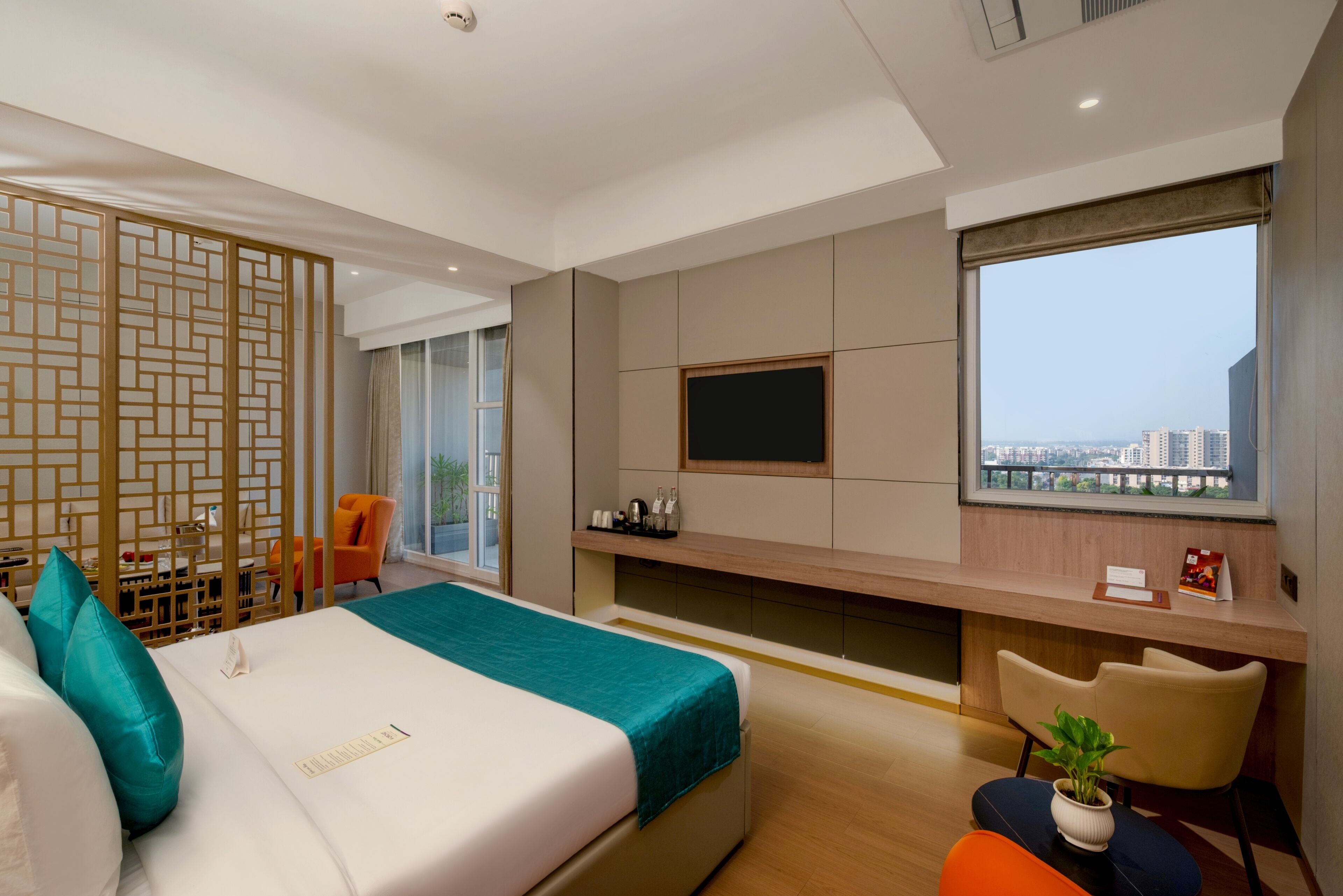 Une chambre d’hôtel moderne équipée d’un lit, d’un bureau, d’une télévision et offrant une vue sur la ville.