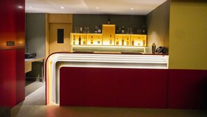 A bar area with a counter and shelves of bottles.