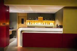 Un espace bar avec un comptoir et des étagères remplies de bouteilles.