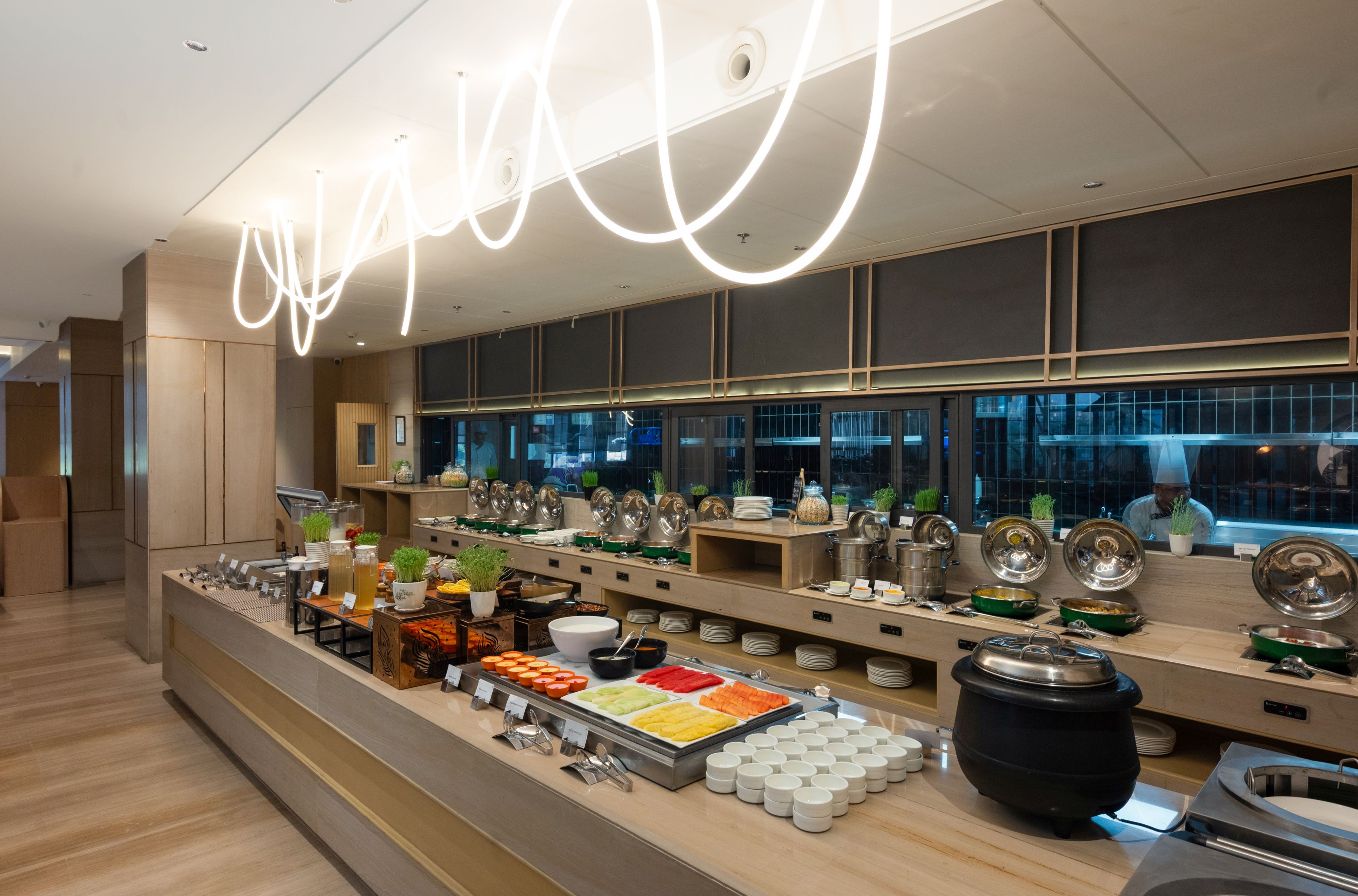 A buffet setup with various food items and utensils.