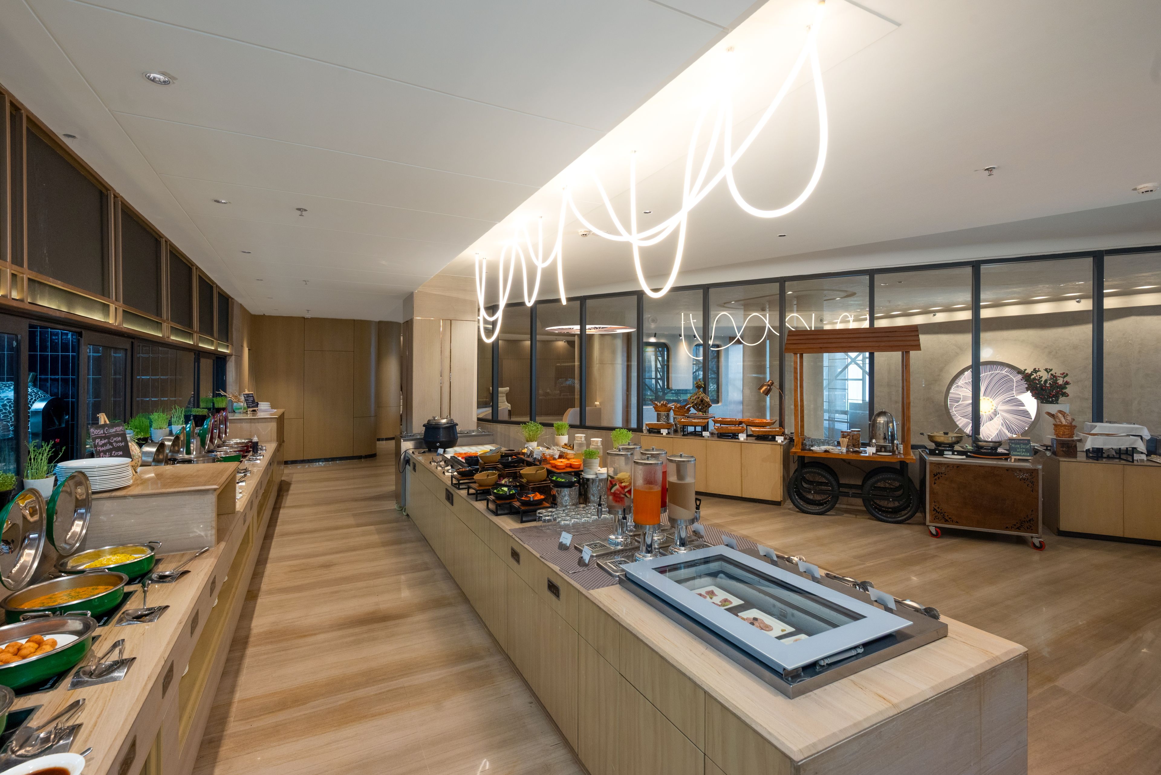 A modern buffet setup with various food stations and a central display area.