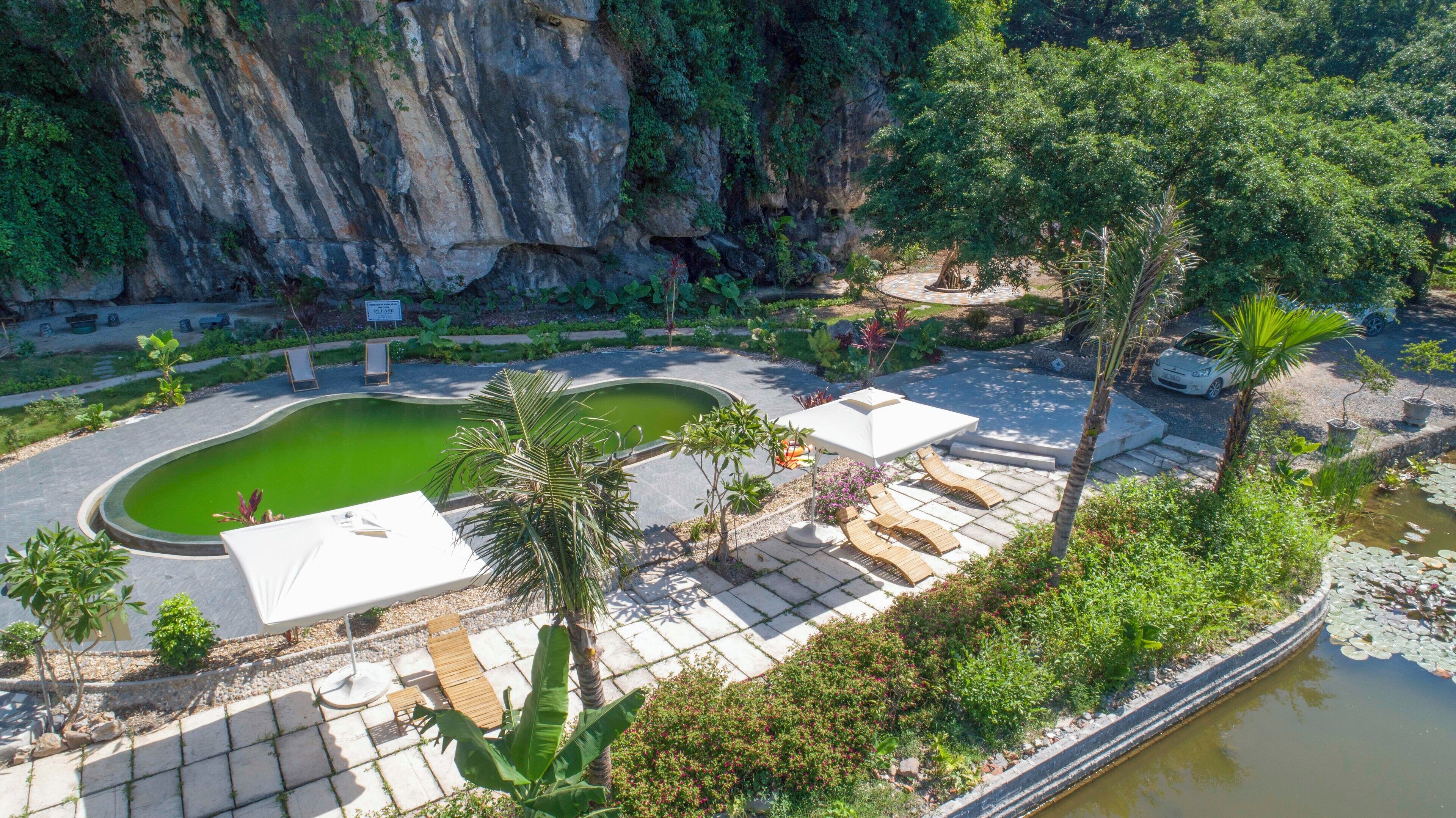 A pool area with lounge chairs and a sign that says "PLEASE".