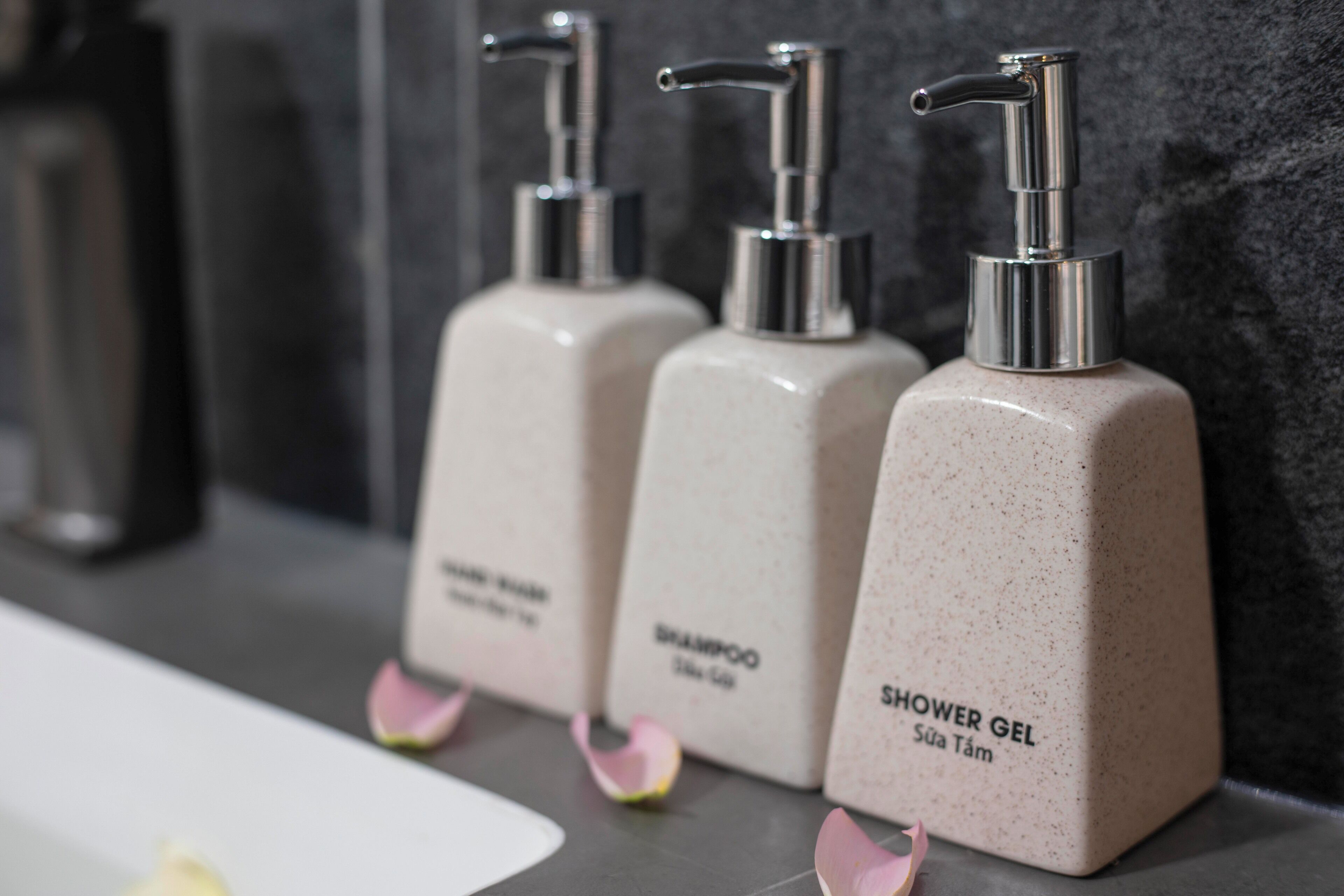 Three toiletry bottles labeled 'Shampoo' and 'Shower Gel' on a countertop.