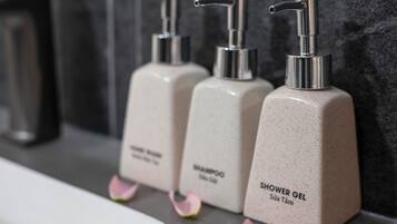 Three toiletry bottles labeled 'Shampoo' and 'Shower Gel' on a countertop.