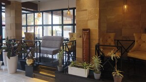 A modern lobby with seating areas, large windows, and potted plants. - Hotel Palace View (Lalbag)