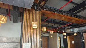 A modern reception area with wooden paneling, a reception desk, and pendant lighting. - Hotel Palace View (Lalbag)