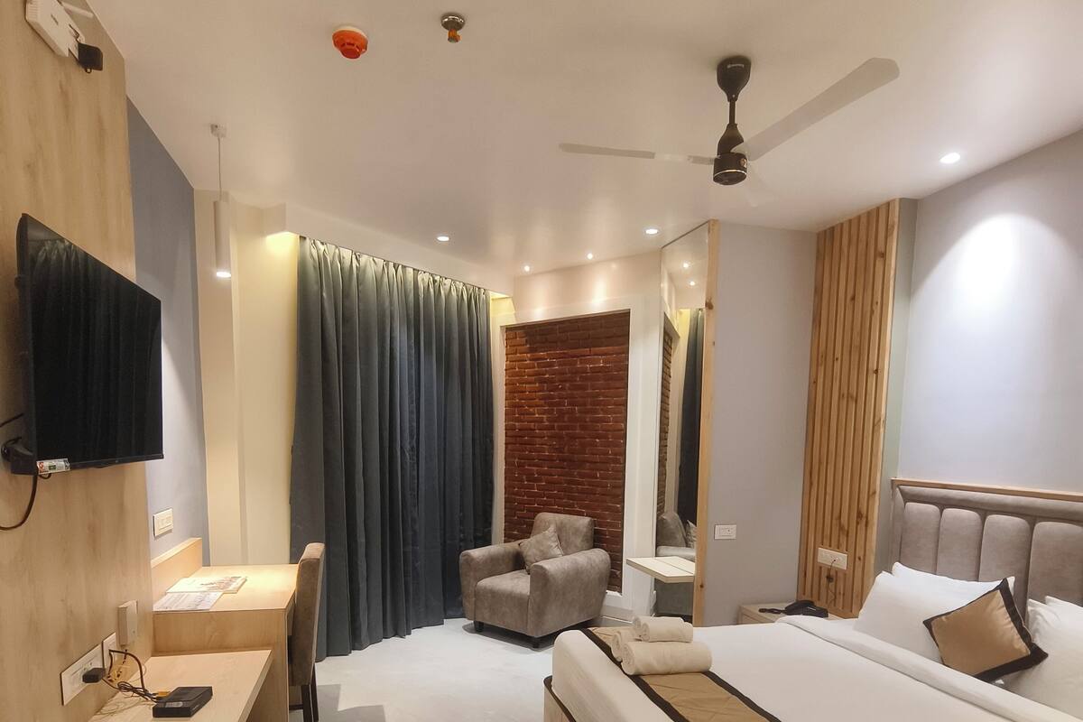 Una habitación de hotel moderna con cama, escritorio, silla y televisión.