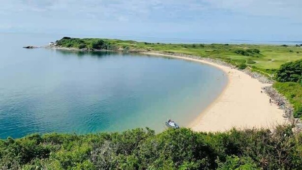 A coastal landscape with a sandy beach, calm water, and green vegetation. - Secluded Mountain Stay - Stunning Views of Eryri (Dolgellau)