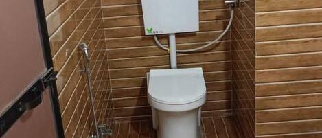 Un bagno piccolo e chiuso con il water, una doccia e un riscaldatore a parete.
