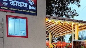 A building with a sign for a hotel named "Kolkana Inn" offering A.C & Non A.C rooms and Wi-Fi. - Kokan Inn (Dapoli)