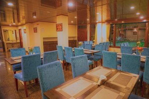 Enjoy meals in a stylish dining area with tables, chairs, and artwork.