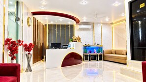 A modern reception area with a reception desk, a fish tank, and a sofa. - The Kelvish Plaza (New Delhi)