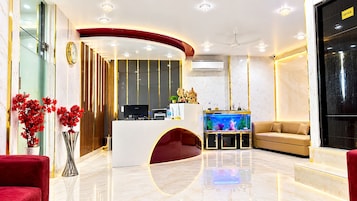 A modern reception area with a reception desk, a fish tank, and a sofa.