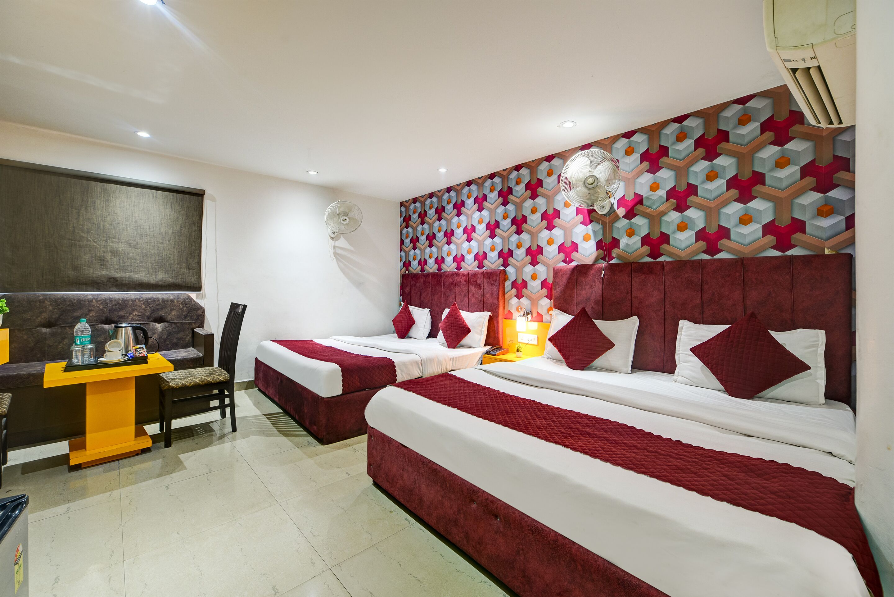 A hotel room with two beds, a desk, and a chair.